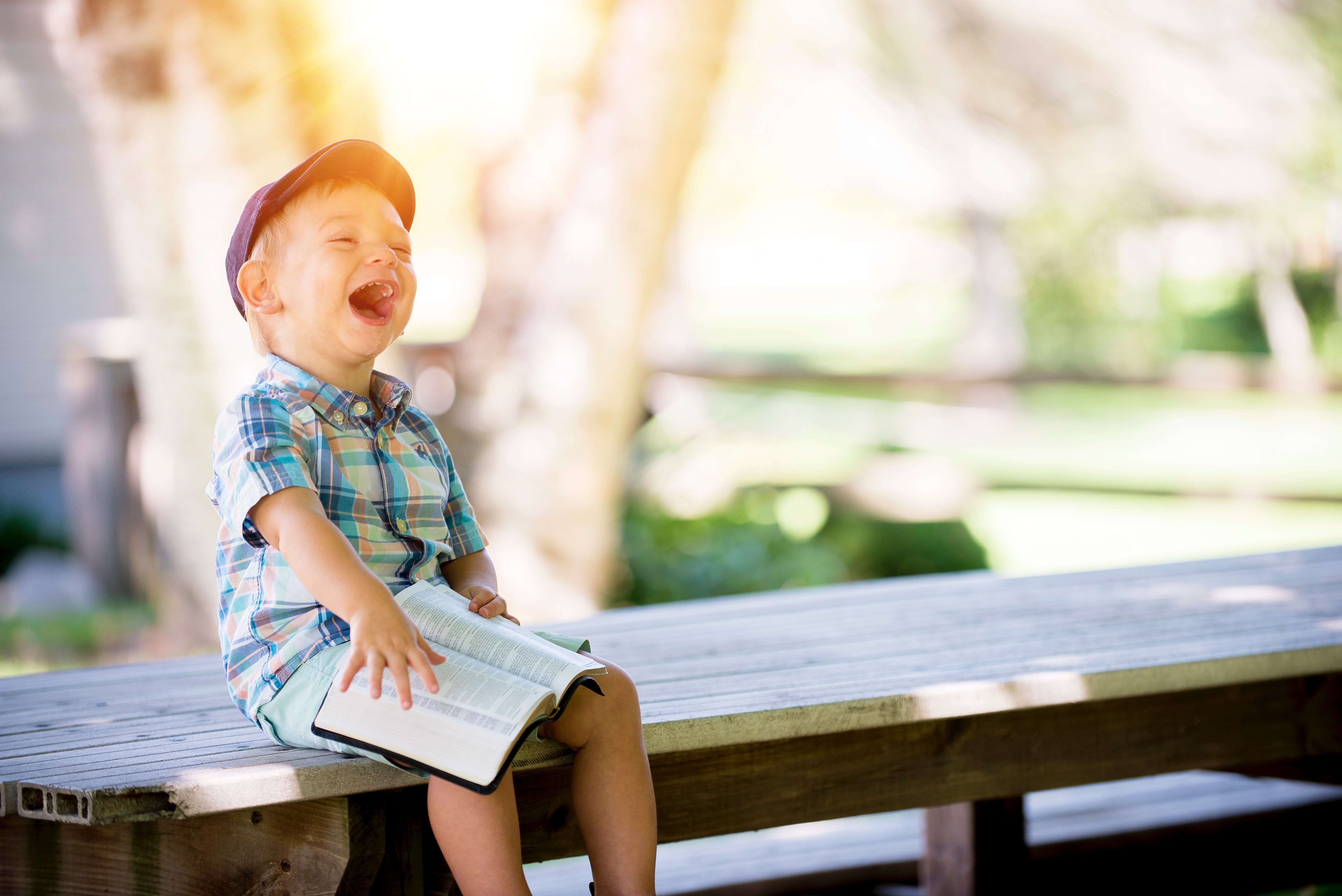 little boy laughing on bench